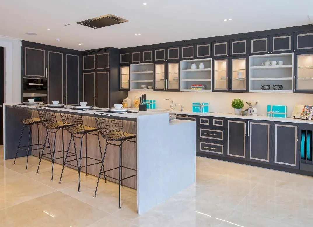 Large kitchen with dark painted cabinets and a long island with a white stone top, Kingston