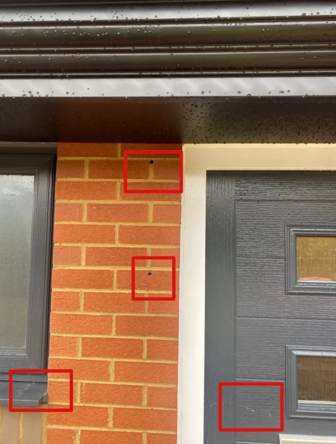 Brickwork beside a front door with four small defects marked in red boxes