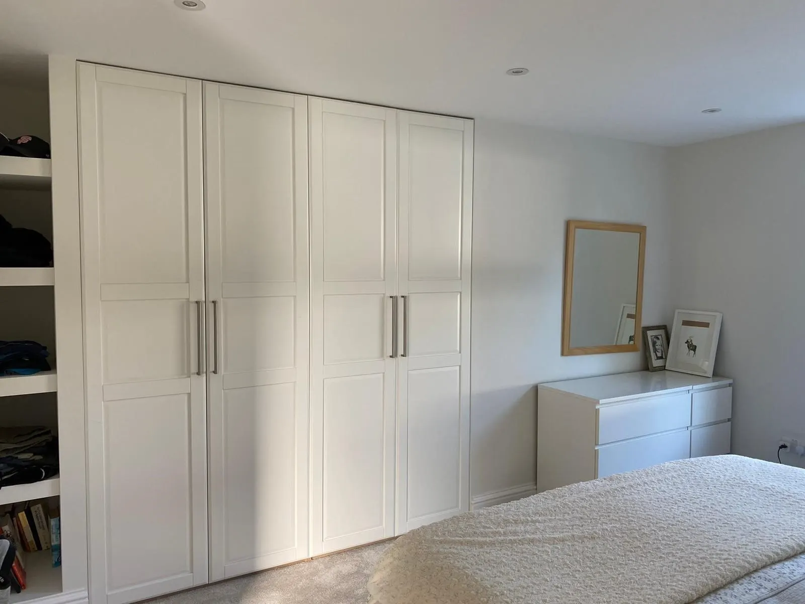 Bedroom with a run of white panelled fitted wardrobes, Weybridge