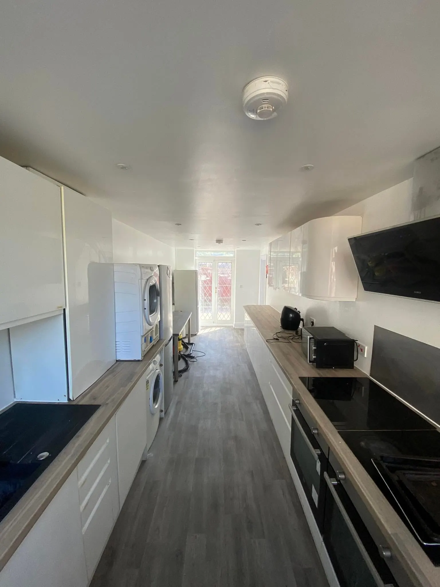 A galley kitchen after its repair: new worktops, white units and a clean ceiling