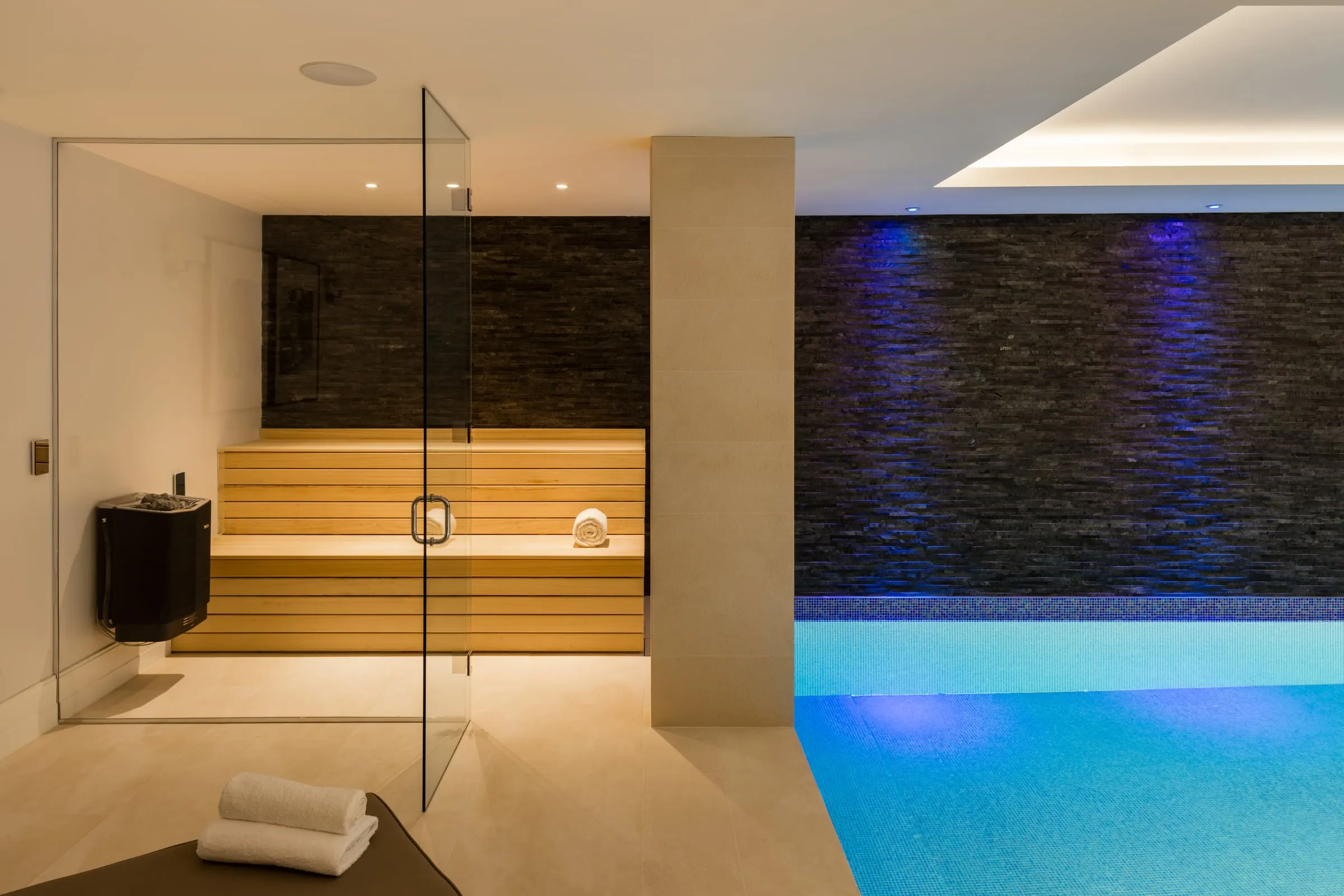 Glass-fronted sauna beside an indoor pool