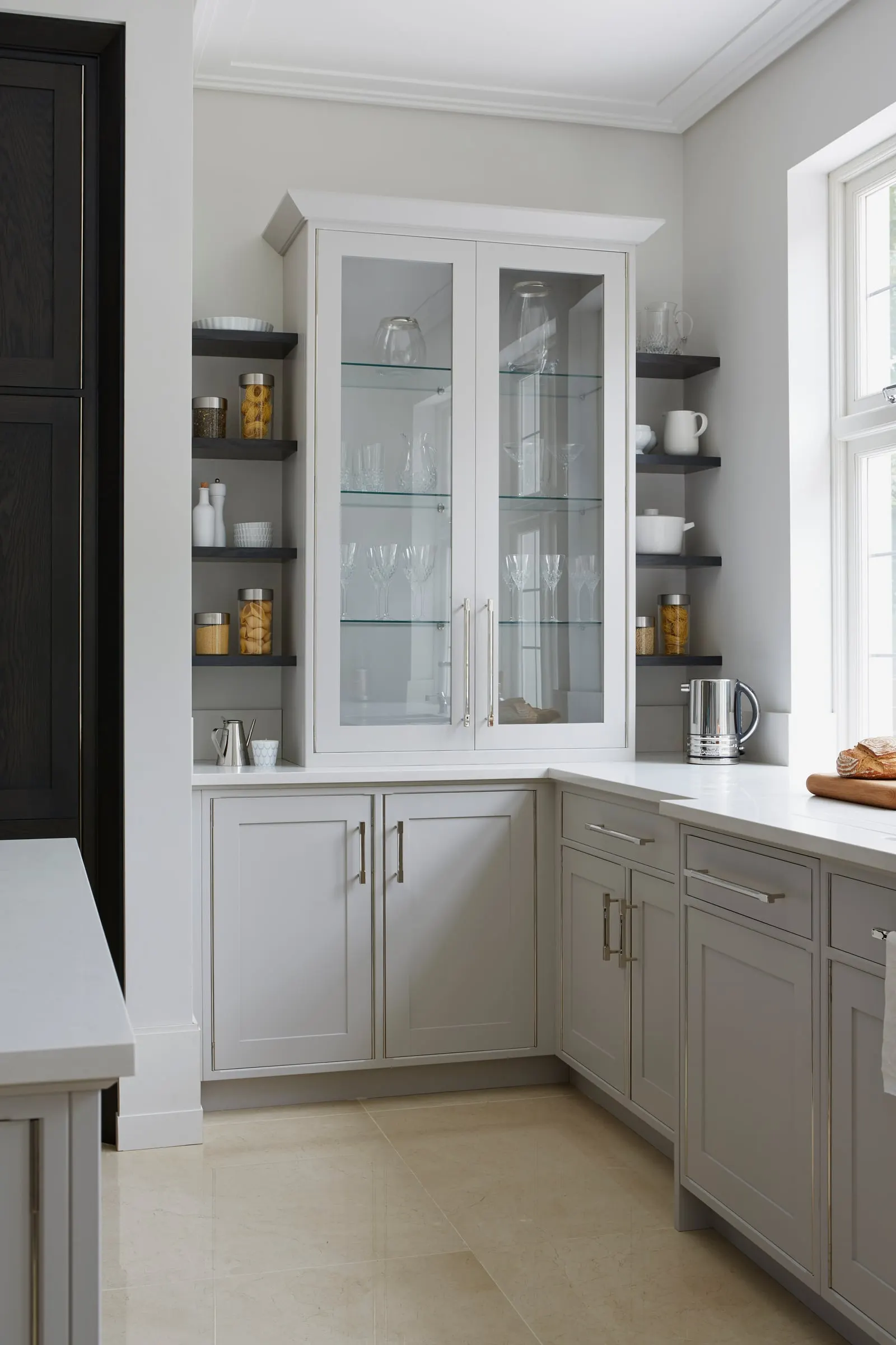 Painted kitchen units with glazed wall cabinets and open shelves over a white stone worktop, Kingston