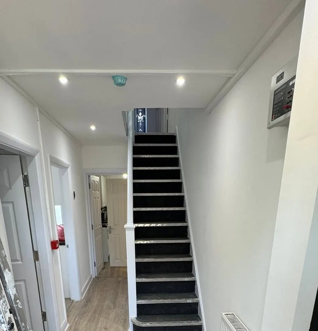 The same hall after: a new ceiling with downlights over the stairs