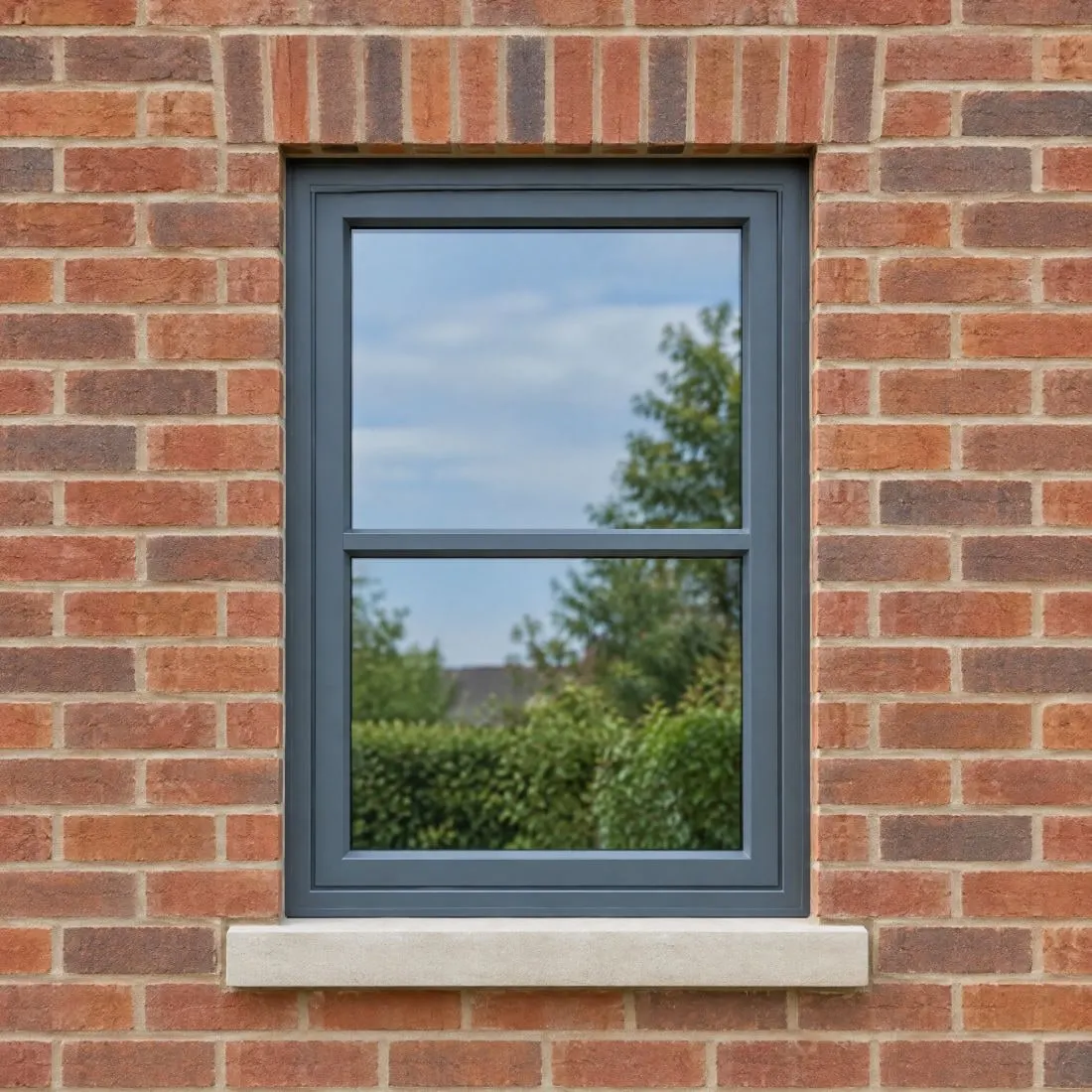 Grey-framed window set in a red brick wall, seen square-on